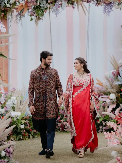 The couple walking through a floral archway at their 'Sunny Sway Soirée'.
