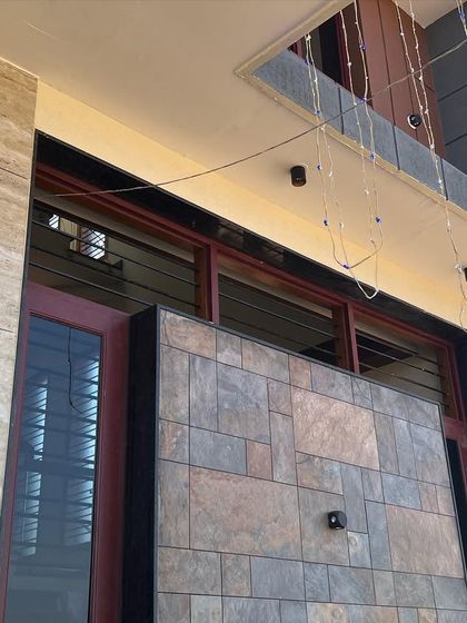 A close-up of the exterior details at Mr. Kantraj's home, showing the combination of stone cladding and textured paint that adds depth and character to the facade.