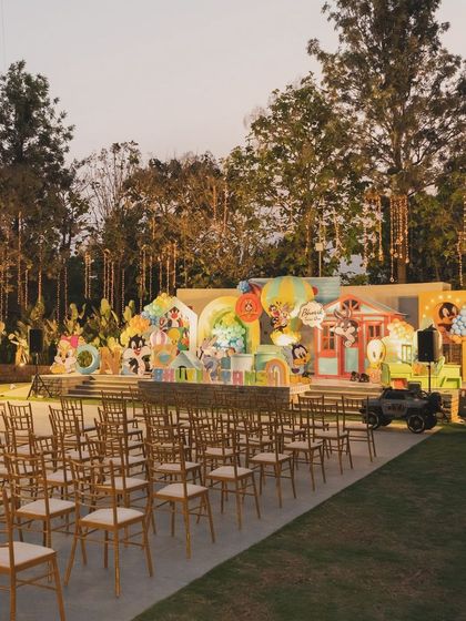 A wide shot of the outdoor venue for the Looney Tunes party, showing the large stage and guest seating area.