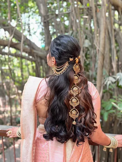 The hairstyle is just as important as the makeup. Here, you can see the intricate traditional hair accessories woven into her braid, completing the royal Maharashtrian bride aesthetic.