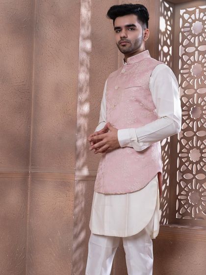 The rose pink bundi set, shown against a textured backdrop. The soft pastel tone is ideal for daytime celebrations and summer weddings, offering a sophisticated and stylish option.