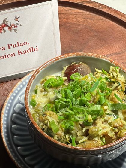 A close-up of our Undhiya Pulao with Spring Onion Kadhi, garnished with fresh spring onions. This dish is a perfect example of how we reinterpret traditional recipes for a modern audience.
