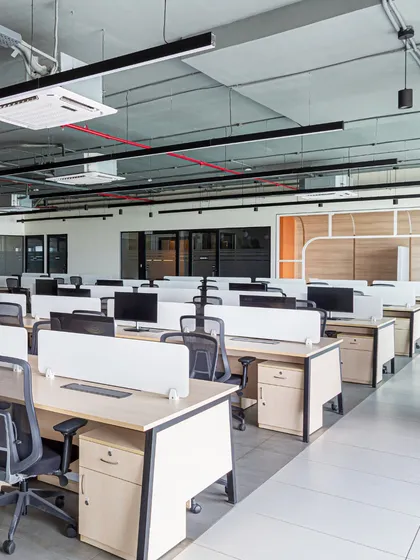 The main workstation area is designed as an open plan to maximize natural light and encourage fluid movement. The exposed ceiling with clean, linear lighting adds an industrial touch while keeping the space feel airy and expansive.