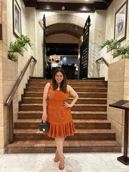 Wearing a beautiful tangerine fluted dress by Tilsim by Sagarika for a dinner at La Piazza. The color and silhouette were perfect for a summer evening at an iconic Italian restaurant.