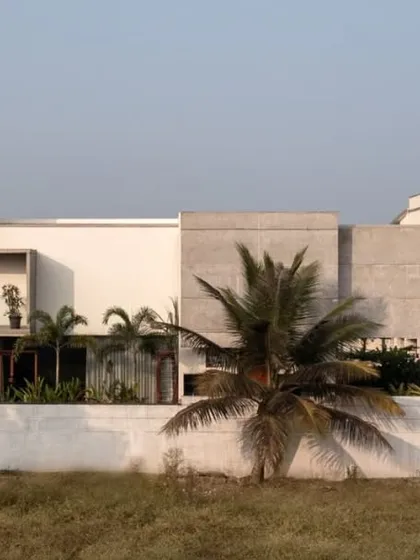 The side elevation of The Quarry House shows a composition of solid white and textured concrete volumes. This play of materials and forms creates a dynamic and visually interesting facade that changes with the light.