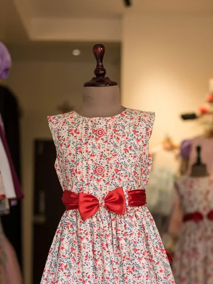 A beautiful floral print dress with a simple silhouette. I added a bold red satin bow to give this classic design a striking and memorable accent.