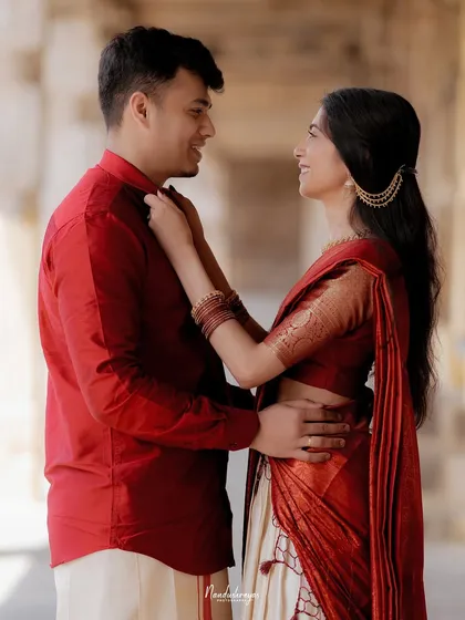 A sweet, interactive moment as the bride-to-be adjusts her groom's shirt, showcasing their comfortable intimacy.