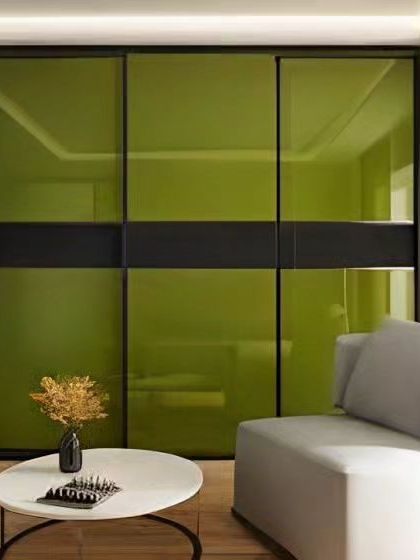 A modern wardrobe with bold, glossy green sliding doors. This design adds a pop of color to the room while providing ample storage and saving space.