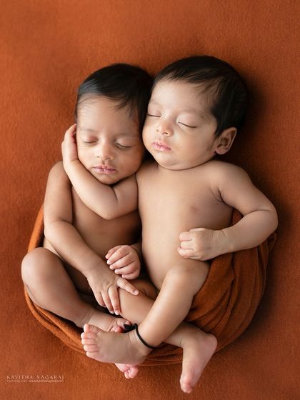 Two newborn twins, connected before birth. This portrait captures their magical bond as they rest together, their heartbeats in sync, just as they were in the womb.