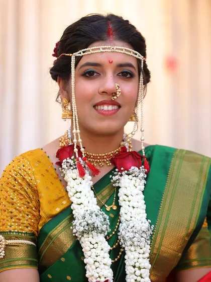 A frontal view showing the delicate mundavalya and nath. The makeup is kept clean with a focus on glowing skin to balance the traditional jewellery.