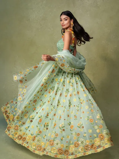 An action shot for a lookbook, capturing the beautiful flare of a floral lehenga. Showing movement is a great way to demonstrate the fabric's weight and flow to online shoppers.