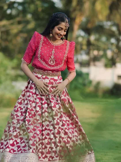 A beautiful shot of our client in a rose pink Banarasi lehenga, with a twirl that shows off the skirt's volume.