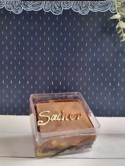 A Sacher Torte dessert box. This classic Austrian dessert features layers of dense chocolate cake with a thin layer of apricot jam, all covered in dark chocolate ganache.
