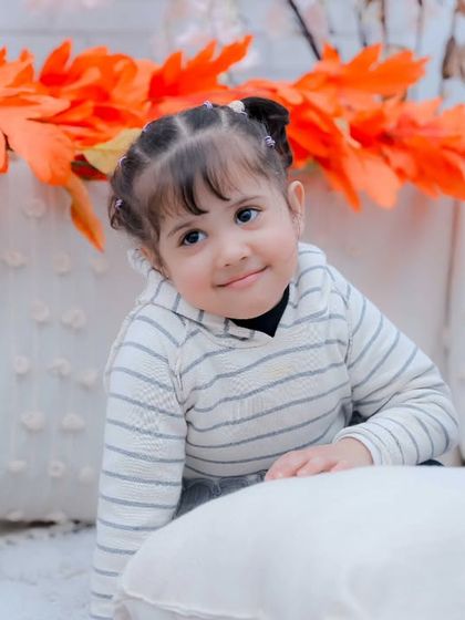 A curious little girl peeking over a pillow. We are always ready to capture those spontaneous, cute moments.