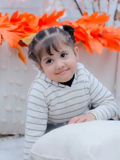 A curious little girl peeking over a pillow. We are always ready to capture those spontaneous, cute moments.