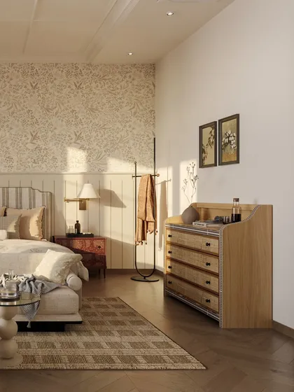 A view of the custom-designed dresser with cane-front drawers, adding a touch of vintage charm. The room is layered with soft wallpaper and paneling to evoke a sense of nostalgia.