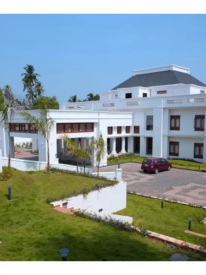 The daytime facade of a large residential project in Kerala. The clean white exterior, minimalist landscaping, and strong geometric forms showcase our expertise in creating grand, contemporary bungalows.