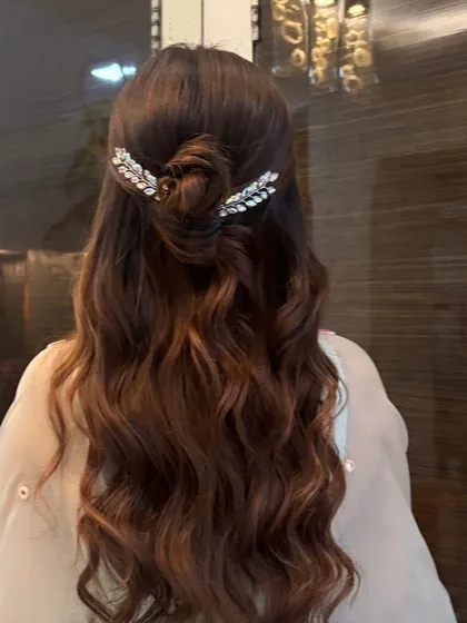 A close-up of the half-up knotted bun with sparkling leaf accessories. This is a very popular style for bridesmaids and wedding guests.