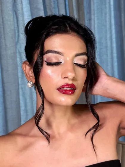 Eyes closed to showcase the stunning, shimmering eyelid and the precise application of the liner and jewels.