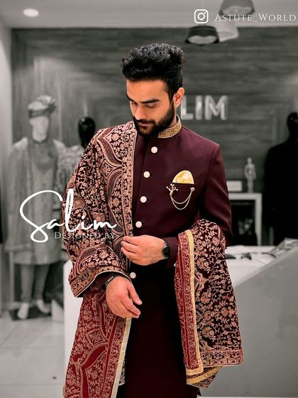 A client wearing a deep maroon Jodhpuri jacket paired with a richly embroidered pashmina shawl. This combination exudes warmth, luxury, and traditional elegance.