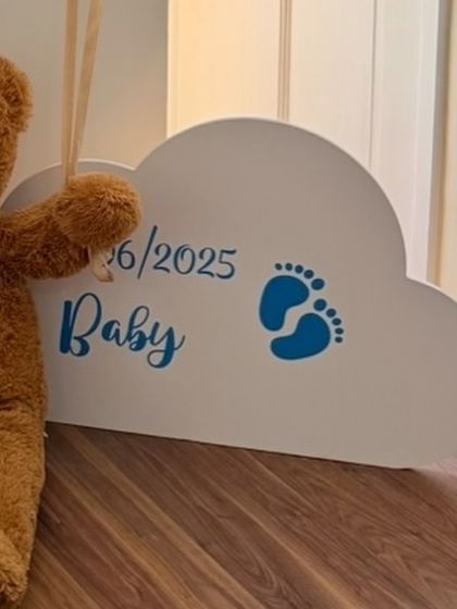 A close-up of the custom cloud-shaped sign with the baby's birth date, a charming detail from the 'Little Prince' welcome home decor.