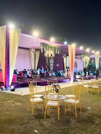 A view of the stage and seating area for a Sangeet or reception, with elegant purple and gold draping.