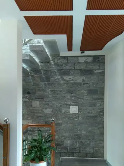 A detail of the ceiling and staircase, where a coffered ceiling with terracotta tiles meets a floating stone staircase.