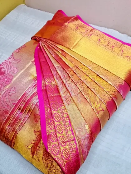 A close-up of a gorgeous pink and gold silk brocade saree.