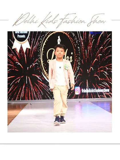 Looking sharp in a light-colored blazer and khaki pants, this participant walks with a calm confidence that is wonderful to see. The firework-like background adds to the celebratory feel of the event.