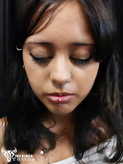 A curated set of facial piercings for a bold look, including a septum ring and a vertical labret piercing. I help you choose jewelry and placement to best suit your style.