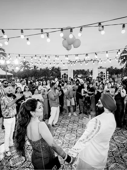 The energy of a celebration is infectious. This wide shot from Jasmine and Rupin's outdoor party captures the scale and joy of the event, with the couple at the heart of it all. We ensure the atmosphere of your celebration is a key part of your wedding film.