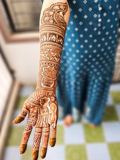 A full view of one arm, showcasing the combination of portraits, animals, and traditional patterns.