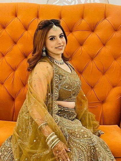 A happy smile from a beautiful bride-to-be in my olive-gold rental lehenga. The outfit is paired with a matching necklace and maang tikka, completing her festive look.