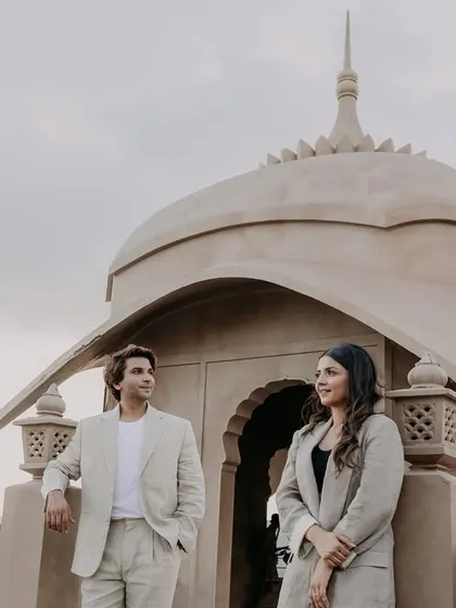 A quiet, posed portrait on a balcony overlooking the Jaipur landscape. The soft light and their calm expressions give this pre-wedding photo a serene and elegant feel.