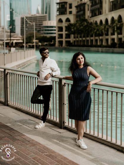 A relaxed portrait against the turquoise waters of the Dubai Canal, showcasing a casual and stylish side of the couple's story.