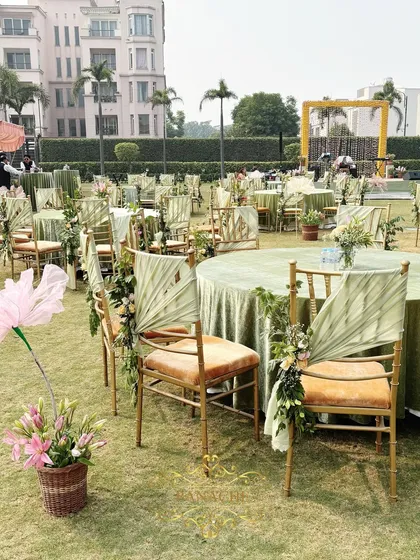 A row of beautifully decorated guest tables and chairs on the lush lawn.