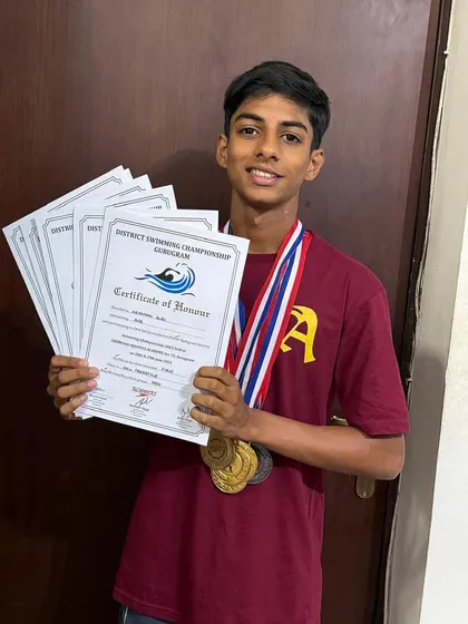 Aryaman Suri proudly displays his collection of medals and certificates of honor from the District Swimming Championship. Each one represents a milestone in his development as a competitive swimmer, reflecting his hard work and the success of our program.