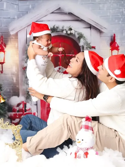 A playful moment during a family Christmas session, with the parents lifting their baby high in the air. These are the candid memories you'll cherish forever.