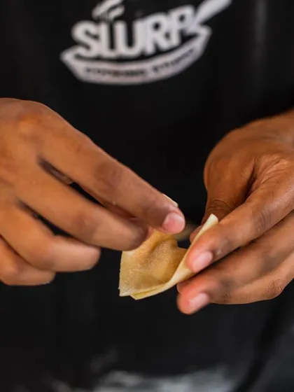 A close-up of a student's hands carefully shaping dough. This level of detail is what separates a good cook from a great chef.