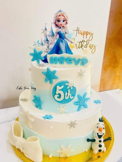 A frosty and fabulous Frozen-themed cake for a 5th birthday. This two-tier design features Elsa, a fondant Olaf, and delicate snowflake details for a true winter wonderland feel.