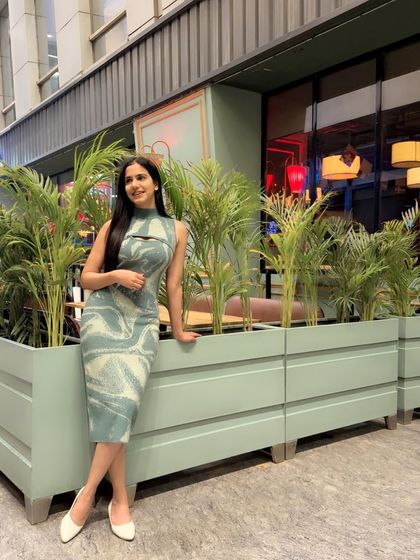 A relaxed and happy pose in the same dress, leaning against a planter. This shows a more casual and relatable side.