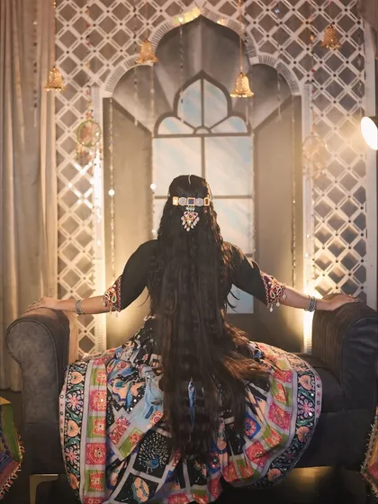 A beautiful back shot showcasing the intricate hairstyle and the flow of the long hair and lehenga.