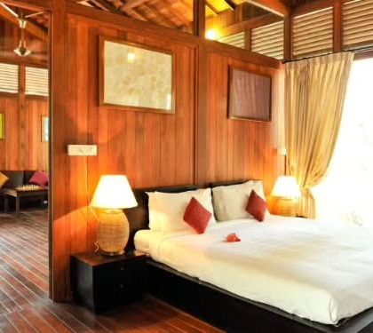 The warm, wooden interiors of a luxury suite at a nature lodge in Coorg, offering a spacious and comfortable retreat after a day of exploring the plantations.