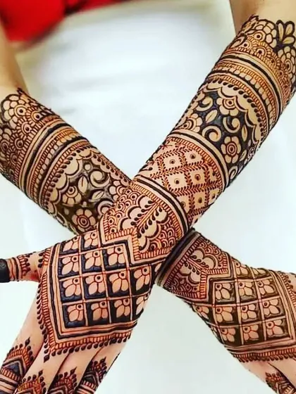 This stunning design uses bold, geometric grids on the back of the hands and intricate floral work on the inside, creating a beautiful contrast.