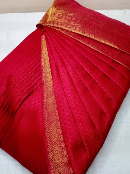 A classic red saree with a gold border. The pleats are sharp and the saree is ready to be the star of any occasion.