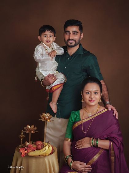 A classic family portrait celebrating the upcoming arrival. The family is dressed in traditional South Indian attire, creating a beautiful and formal portrait that honors their heritage while looking forward to their new beginning.