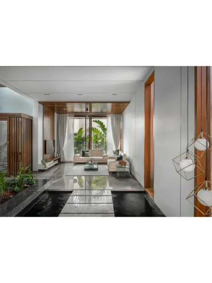 This view of the Janani House shows how I use different floor levels and materials, like black and white marble, to define spaces within an open-plan layout. Indoor planters add a touch of nature.
