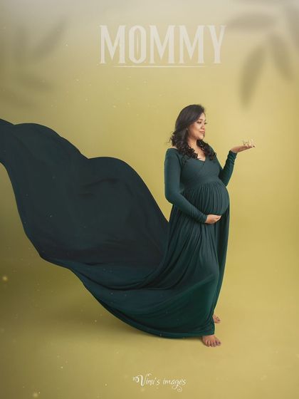 A full-length portrait showcasing the elegance of the long-sleeved green gown. The flowing fabric and the mother's confident pose create a powerful and graceful image.