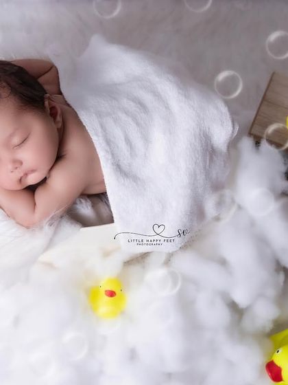 Bathtime fun with rubber duckies! This playful setup uses soft cotton to mimic bubbles, creating a safe and adorable bath scene without any water.