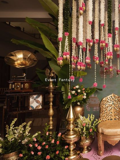For this pre-wedding ritual, I blended vintage and traditional elements. A classic gramophone sits beside brass lamps and hanging floral garlands, creating a unique and nostalgic atmosphere.